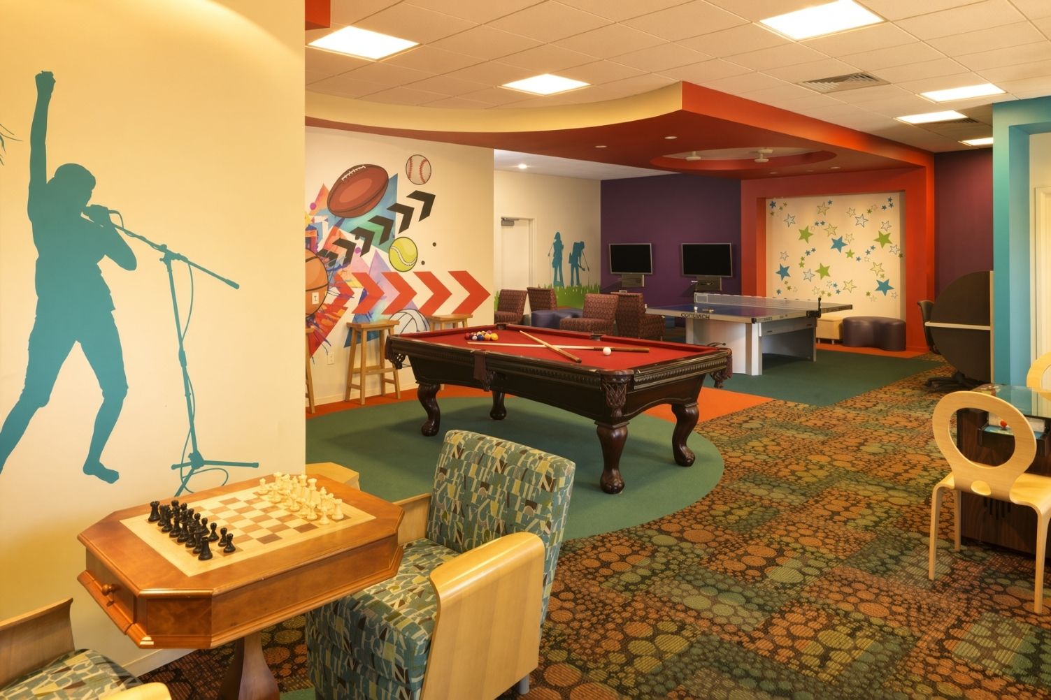 Une salle de loisirs équipée d’une table de billard, d’une table d’échecs et d’une table de jeu de fléchettes.