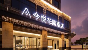 A hotel with a modern facade, large windows, and a prominent illuminated sign.