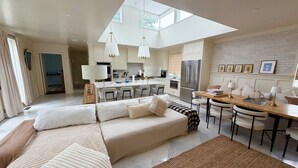 Una sala de estar moderna con un sofá, un comedor y una cocina.