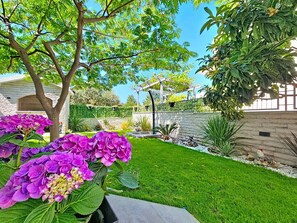 A well-maintained garden with a lawn, a pergola, and a variety of plants. - Vacation home Id&la by Interhome (Brodarica)