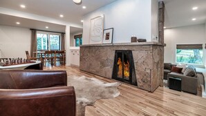 A modern living room with a fireplace, leather sofa, and a chessboard.