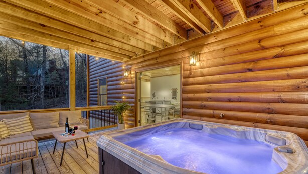 A wooden cabin with a hot tub, wooden deck, and a glass door leading to a kitchen. - Ellijay Escape: Hot Tub, Fireplace, Peaceful Views (Ellijay)