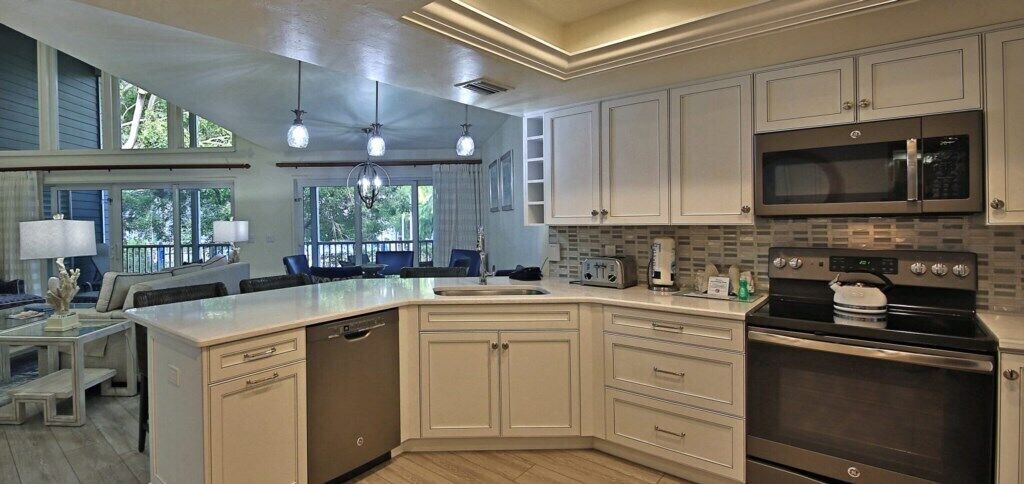 A modern kitchen with a large island, built-in appliances, and a view of the outdoors.