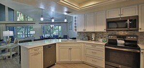 A modern kitchen with a large island, built-in appliances, and a view of the outdoors.