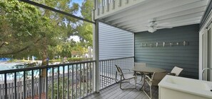 A covered outdoor area with a pool, a table and chairs, and a sink.