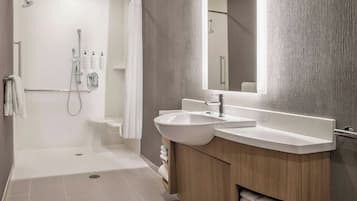 Ein modernes Badezimmer mit Dusche, Waschbecken und Waschtisch.