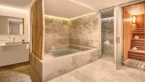 Un baño moderno con una bañera independiente, una sauna de madera y un espejo grande.