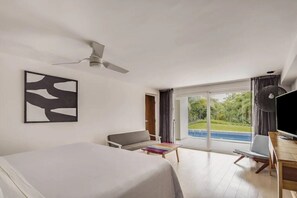 Une chambre d’hôtel moderne dotée d’un grand lit, d’un bureau, d’une chaise et offrant une vue sur la piscine grâce à une porte vitrée.