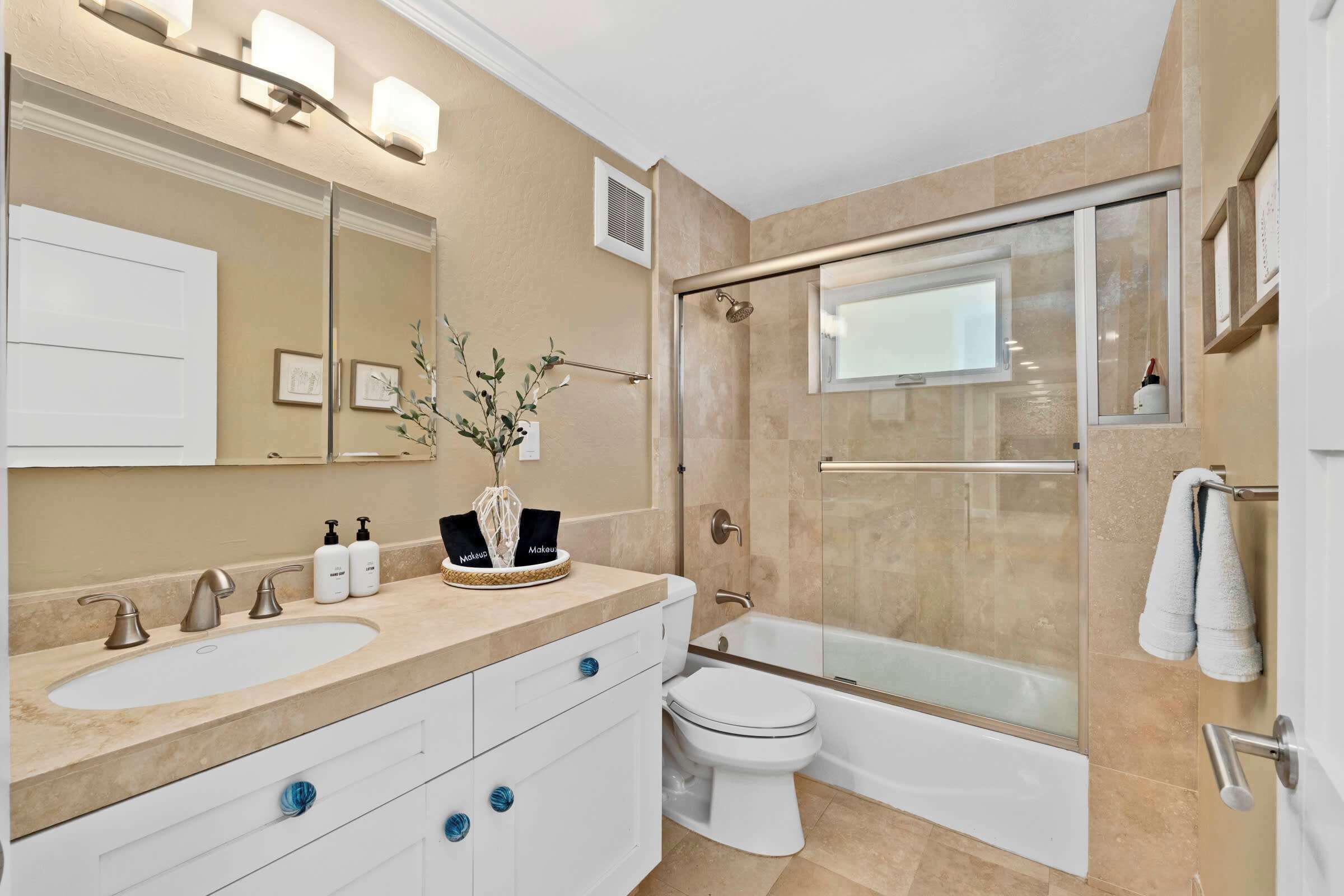 A modern bathroom with two sinks, a toilet, and a glass-enclosed shower.