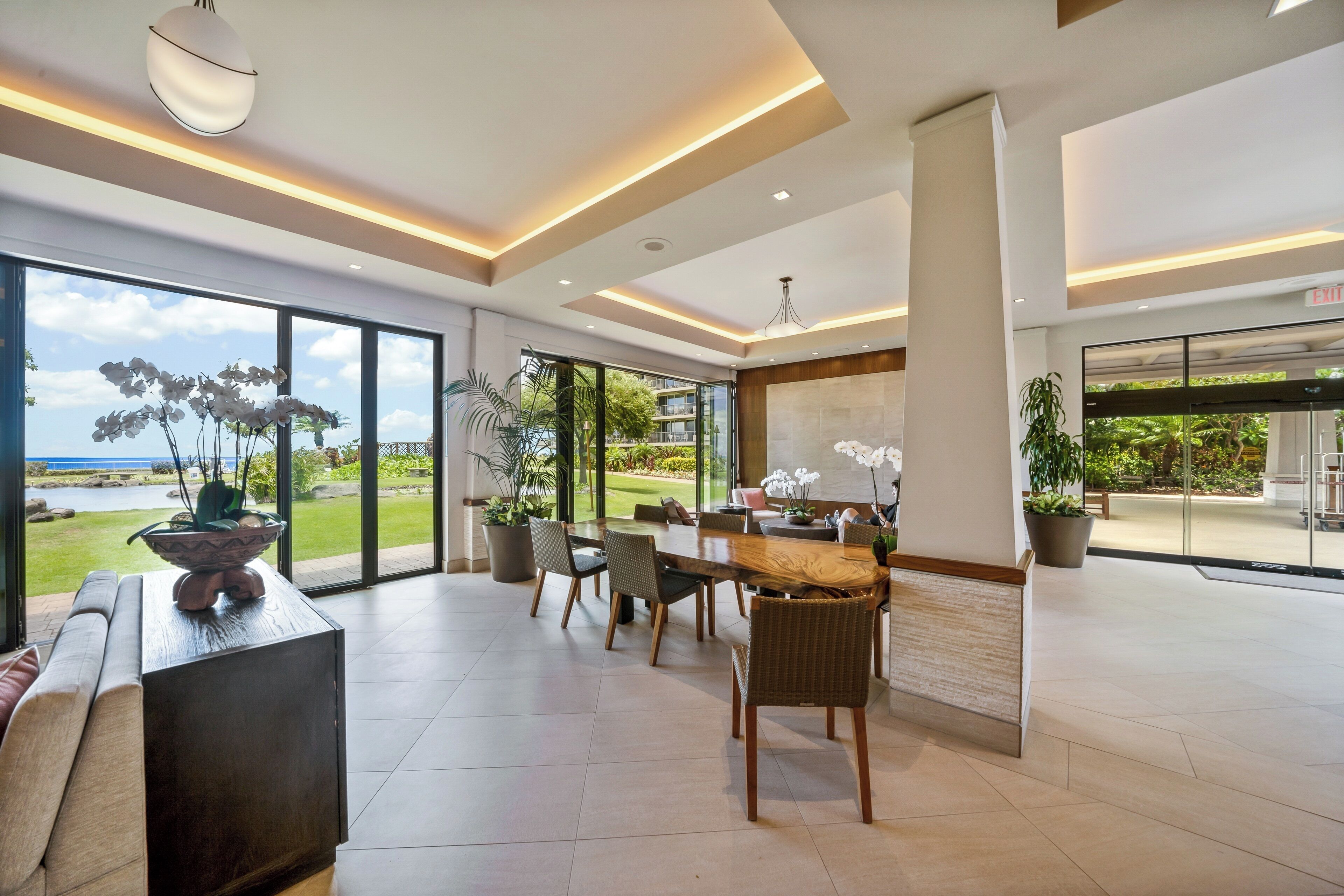 A spacious lobby with a large dining table, comfortable seating, and a view of the outdoors.
