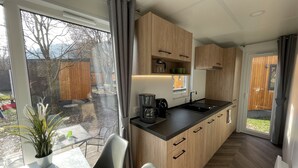 Une cuisine moderne avec des meubles en bois, un plan de travail noir et une grande fenêtre.