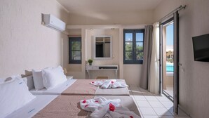 A hotel room with two beds, a desk, a TV, and a sliding glass door to the pool. - Creteco Hotel & Suites (Hersonissos)