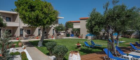 A courtyard with outdoor seating, a large planter, and a pool area with lounge chairs.