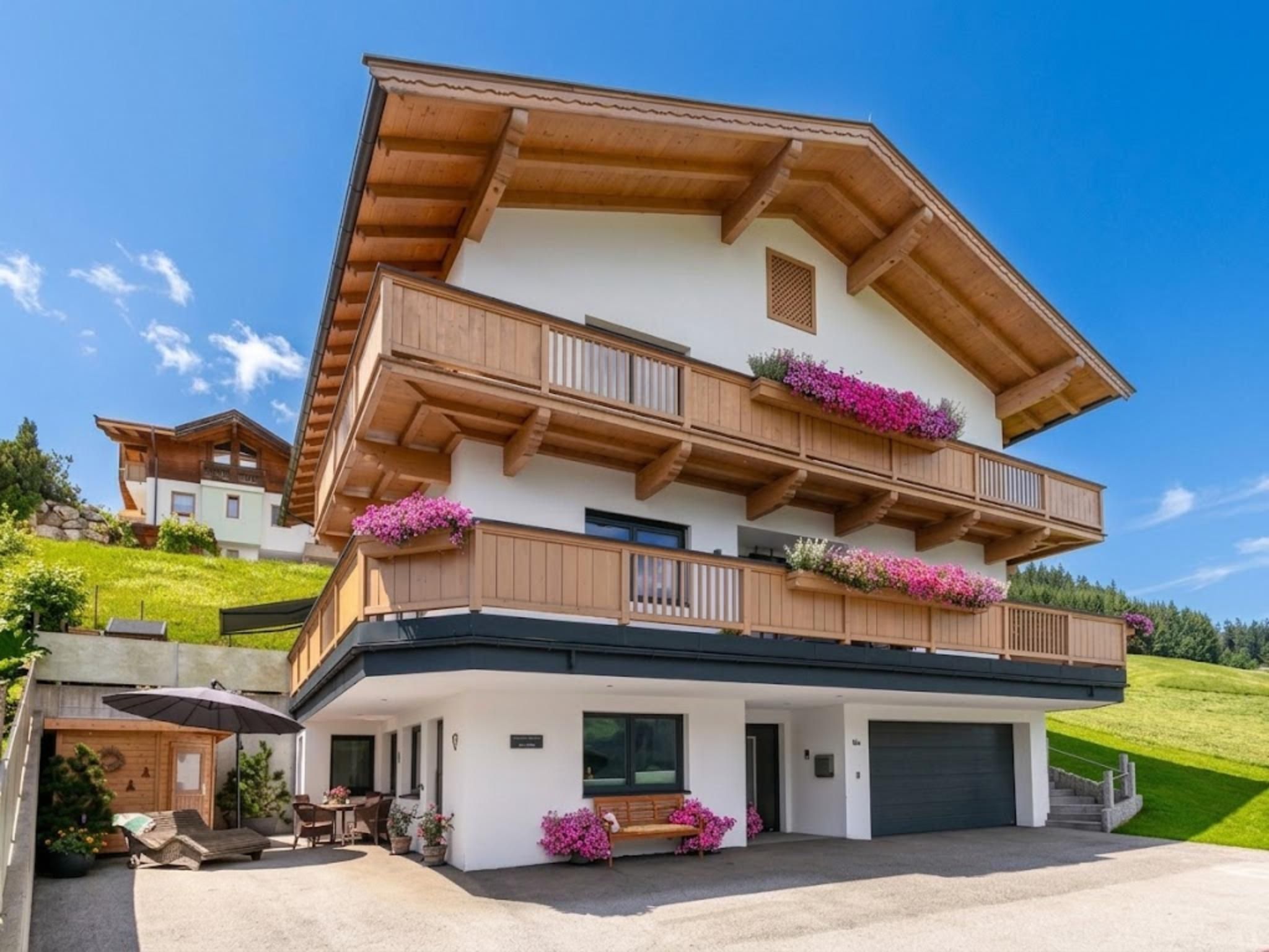 A two-story building with a balcony, a covered porch, and a garage.
