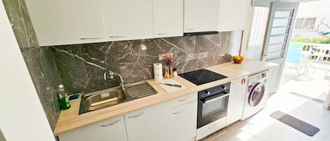 Un four, surface de cuisson, grille-pain, vaisselle et ustensiles