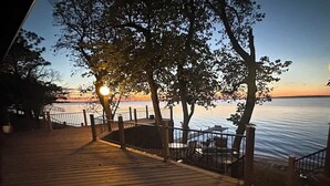 A wooden deck with a railing, overlooking a body of water during sunset. - Sunset Beach View on Otter Tail Lake (Otter Tail)