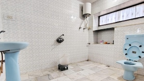A bathroom with a toilet, sink, and shower.