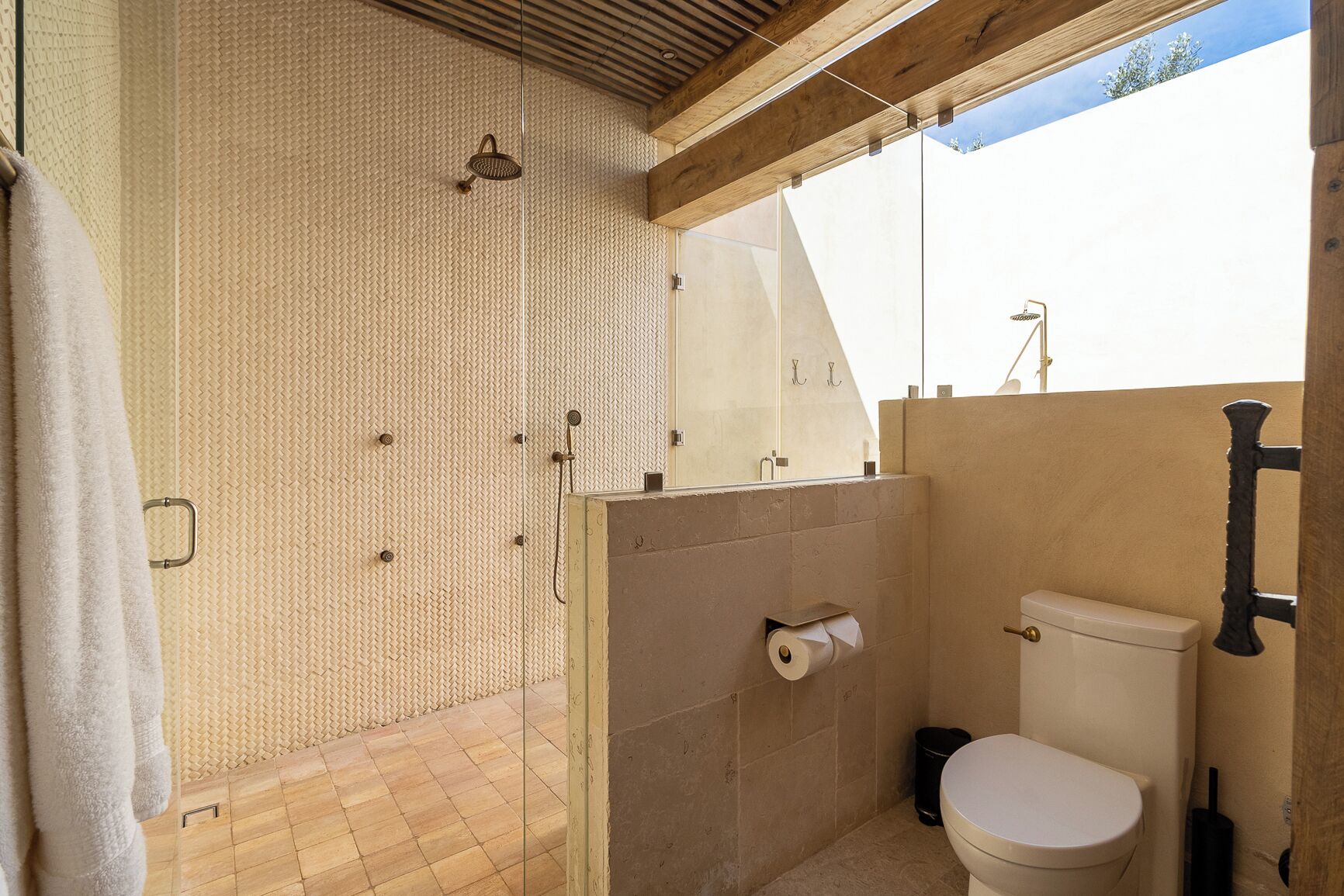 A bathroom with a shower, toilet, and a towel rack.