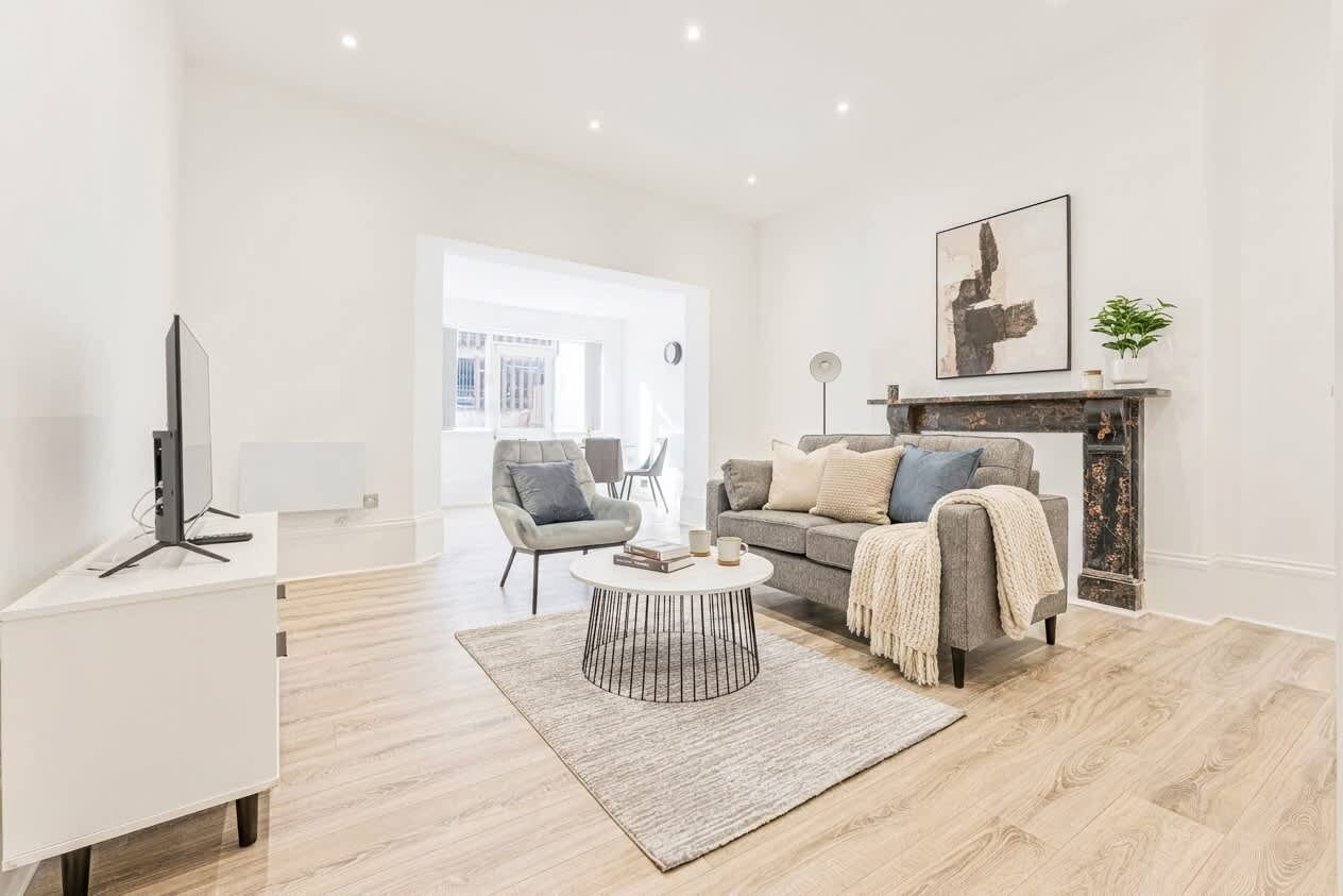 Ein modernes Wohnzimmer mit einer Couch, einem Couchtisch und einem Kamin.