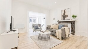 Een moderne woonkamer met een bank, salontafel en een open haard.