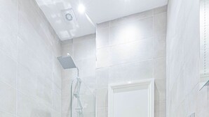 Un bagno moderno con doccia vetro, servizi igienici e lavandino.