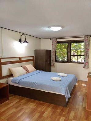 A bedroom with a bed, a nightstand, a wardrobe, a window with curtains, and a ceiling light. - Baan Pak Rim Kuaen Resort (Ban Ta Khun)