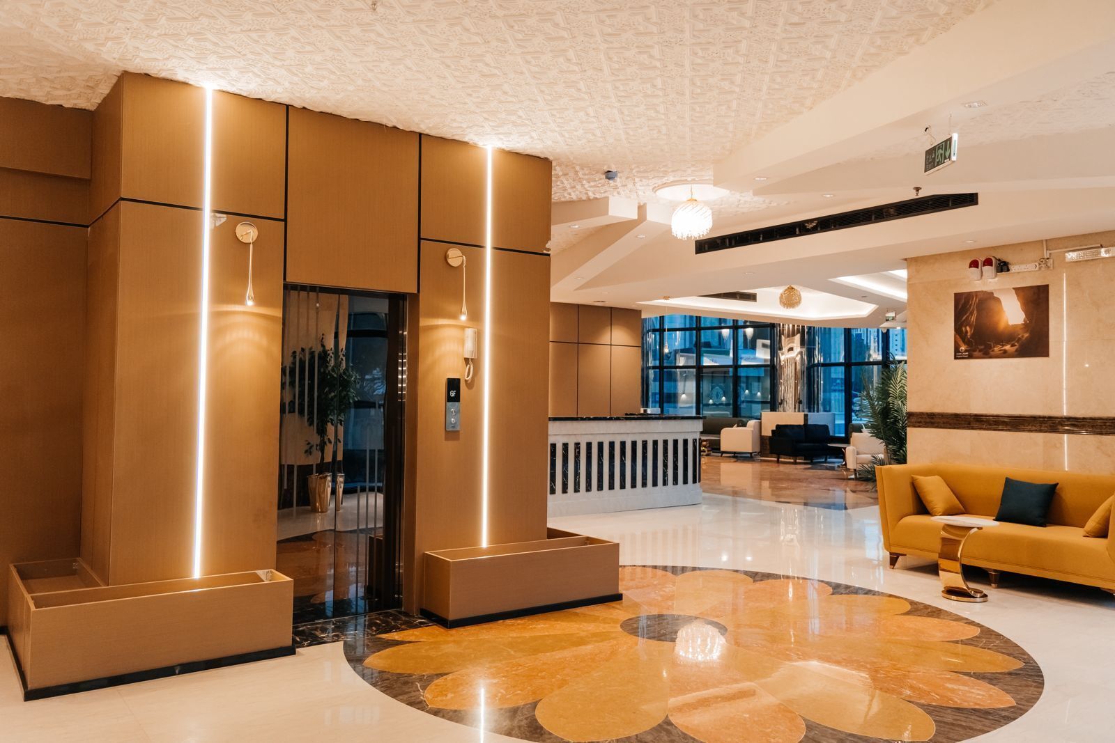 A modern lobby with a reception desk, seating area, and a large, circular patterned floor.