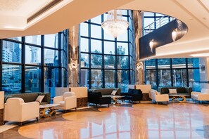A spacious lobby with modern furnishings, large windows offering city views, and a distinctive spiral staircase. - Capital Guest hotel فندق كابيتال جيست العزيزية الجنوبية (Makkah)