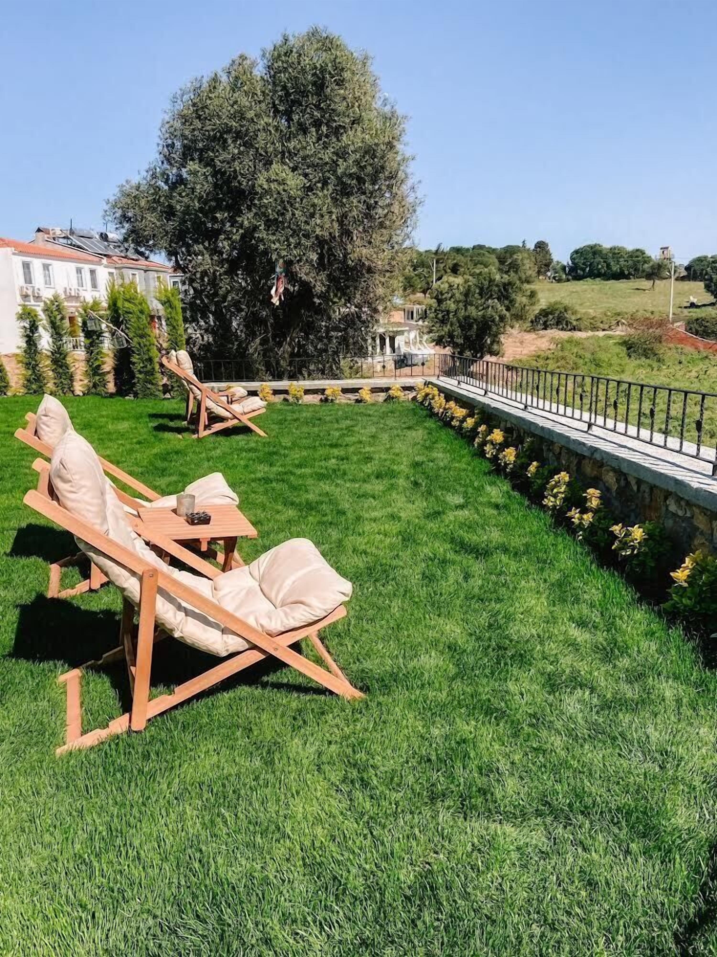 A patio with wooden lounge chairs and a stone pathway.