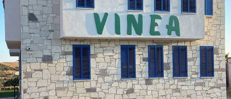 A building with the name "VINEA" in large green letters on the facade.