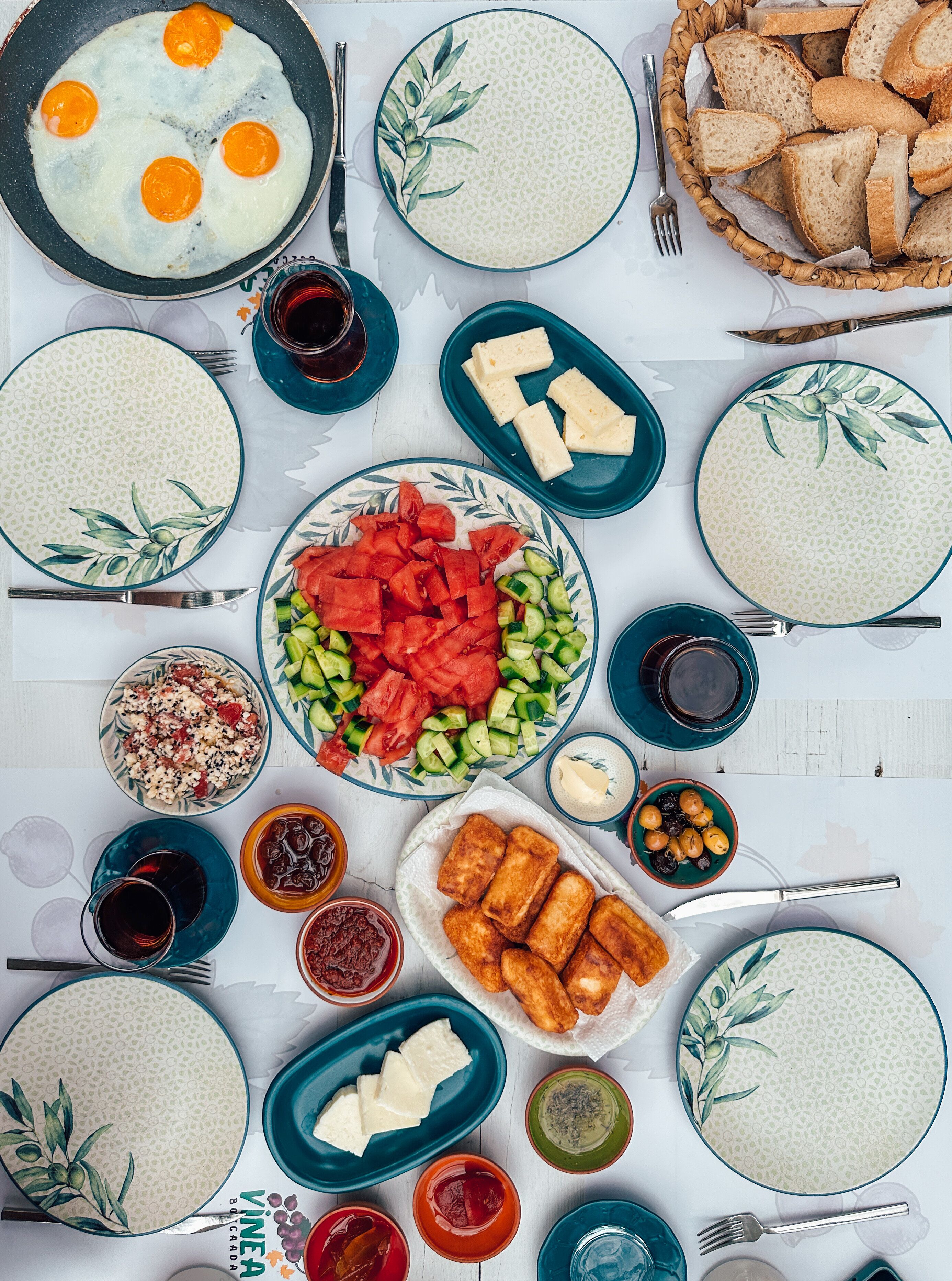 Una mesa servida con diferentes platos, entre ellos huevos, pan y una ensalada.