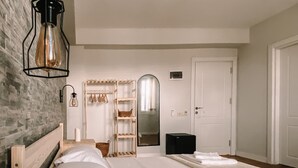 Ein Schlafzimmer mit einem großen Bett, einem Holznachttisch, einem Spiegel und einem Kleiderschrank.