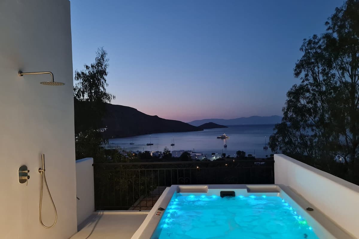 Un jacuzzi con vista al mar y barcos al atardecer.
