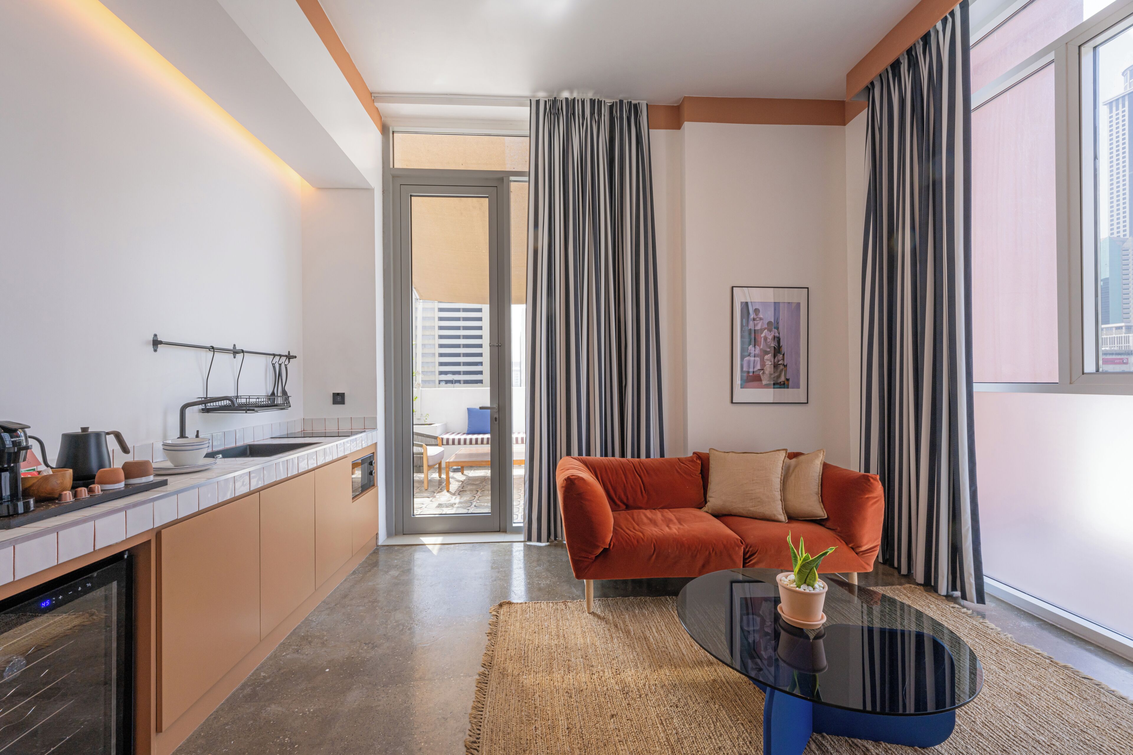 A modern living space with a kitchen, a sofa, and a dining area.