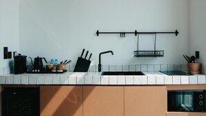 Une cuisine moderne avec un dosseret de carrelage blanc, un robinet noir et un bloc à couteaux noir.
