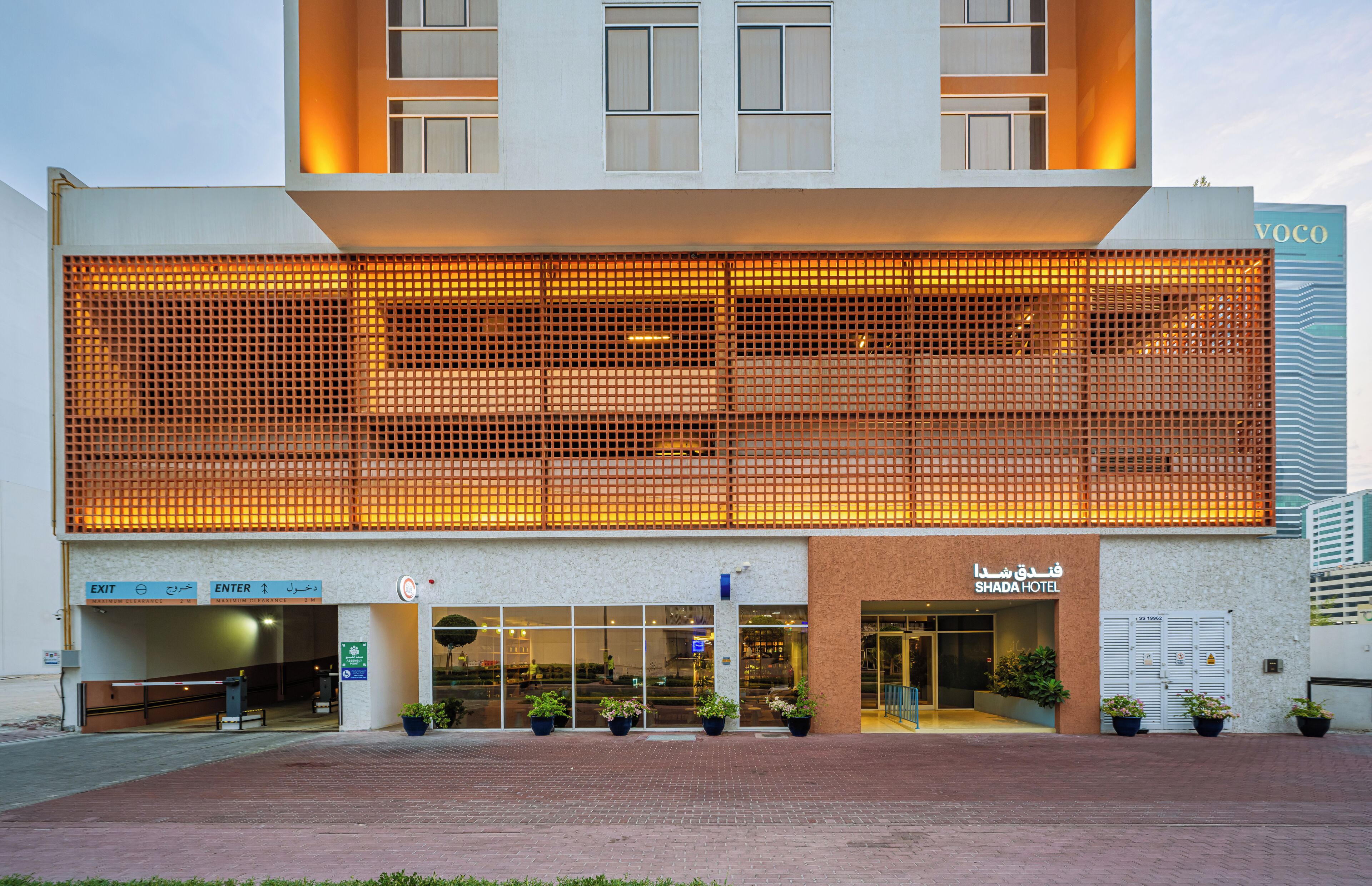 Een hotel met een grote, verlichte gevel en een duidelijke ingang.