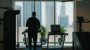 Une salle de sport équipée de tapis de course, d’une machine de musculation et d’un ordinateur portable posé sur une table.