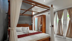 Un dormitorio amplio con una cama de madera con dosel, un ventanal con cortinas y un suelo pulido.