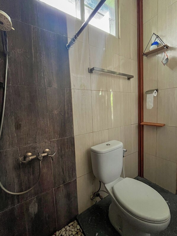 A bathroom with a shower, toilet, and a towel rack.