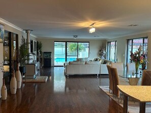 A spacious living area with a large sofa, a dining table, and a kitchen area. - Country Oasis on Evans Street
Entire home in Collie, Australia (Collie)