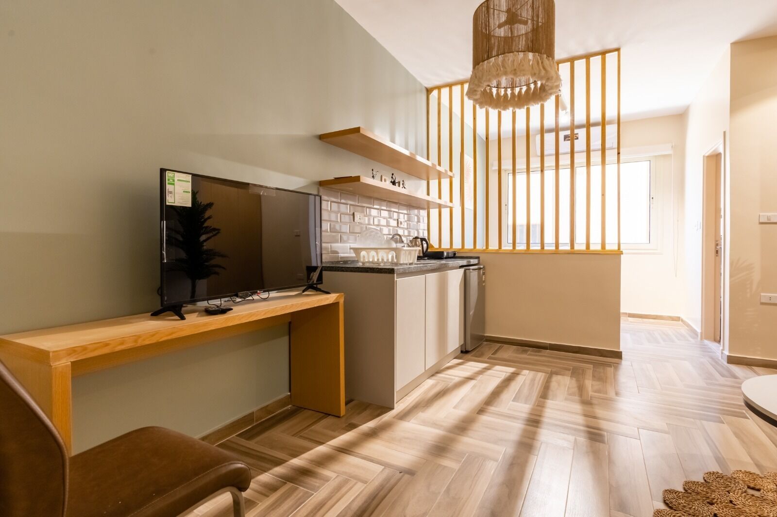 A modern kitchen with a wooden countertop, a built-in oven, and a hanging light fixture.