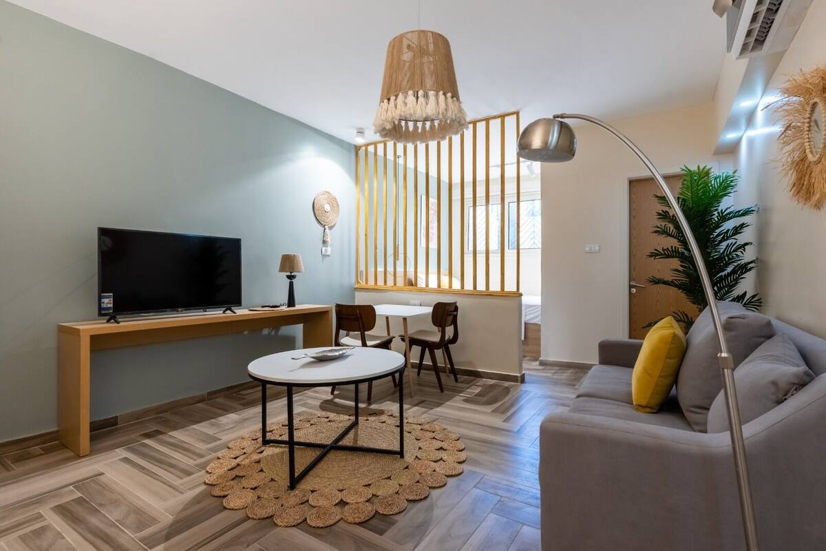 Un salon moderne avec un téléviseur, un canapé et un coin repas.