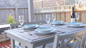 Une table dressée pour quatre personnes, avec des assiettes bleues, des verres à vin et des couverts.