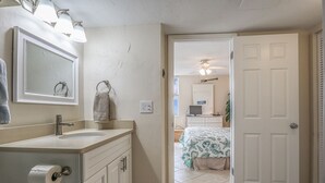 A bathroom with a sink, mirror, towel rack, and toilet paper holder. - Beachfront EBTC 804A w/ Million $ View! Bargain Price! Pool! Tennis! (Fort Myers Beach)