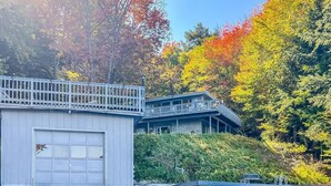 A waterfront property with a dock, a covered boat house, and a building with a balcony.