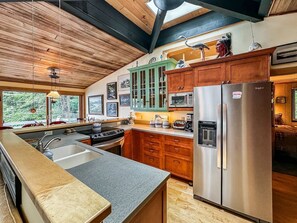 Una cocina con una isla grande, armarios de madera y electrodomésticos de acero inoxidable.