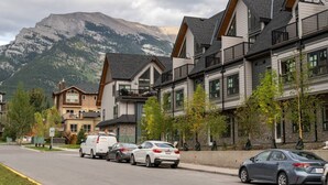 A row of modern multi-story buildings with a mountain backdrop. - Sky Nook - Micro Studio - Pool, Hot Tub & Parking (Canmore)