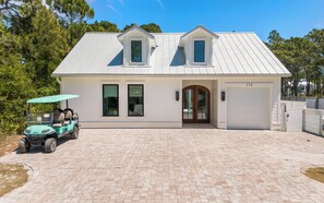A two-story house with a garage, a driveway, and a golf cart. - Slim Shady + Pool, Golf Cart, Easy Access & Bikes (Santa Rosa Beach)