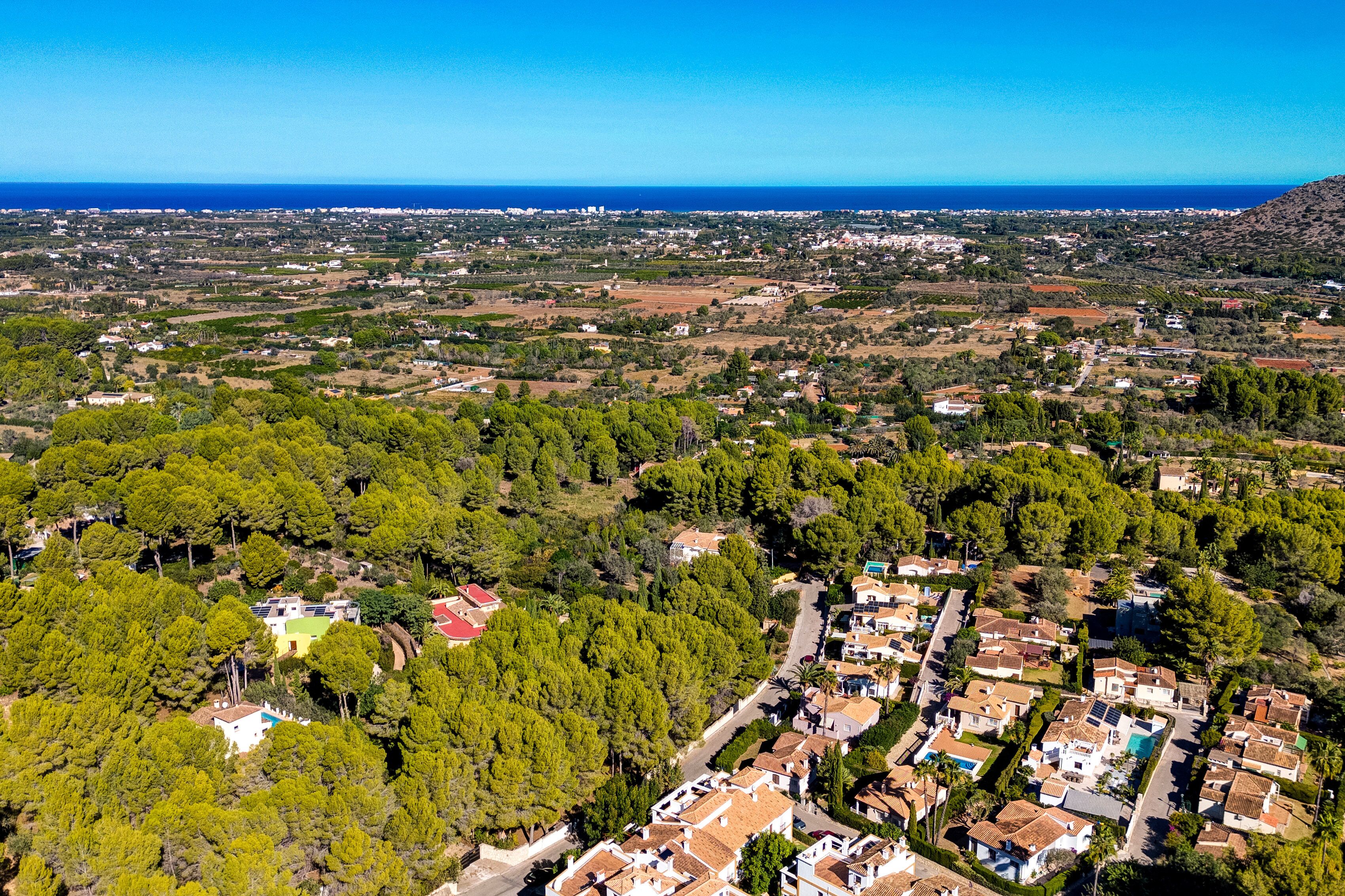 Vue aérienne d’un quartier résidentiel avec des maisons, des routes et une côte.
