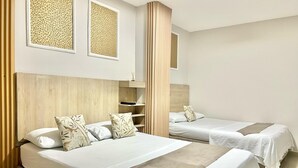 A hotel room with two beds, a wooden headboard, and a small shelf with a decorative item.